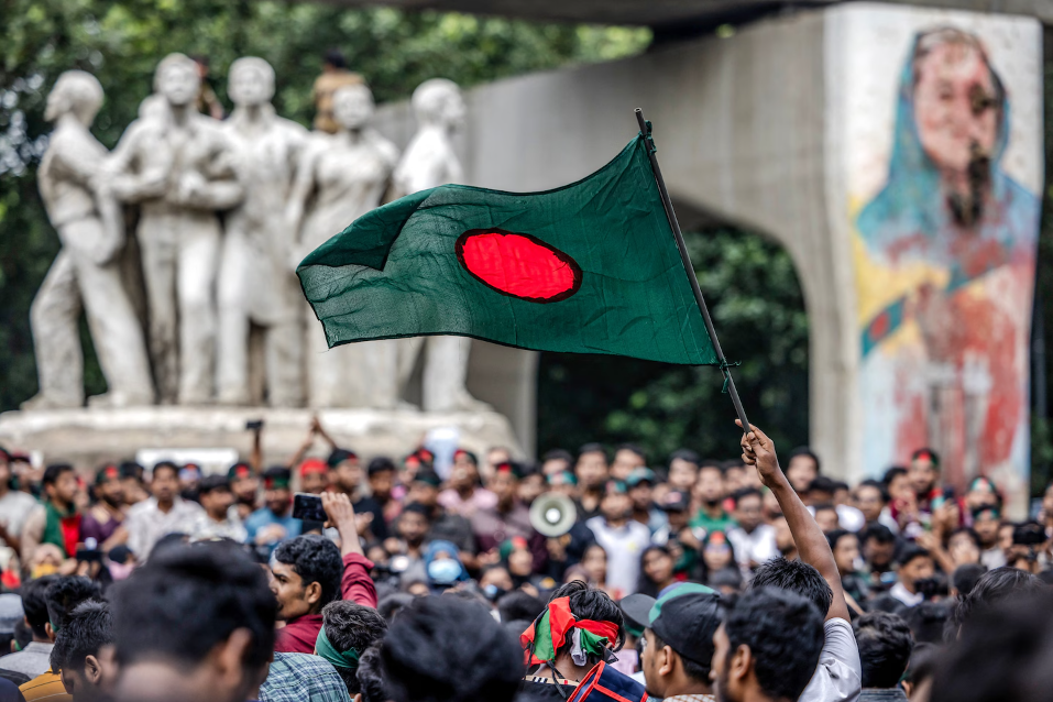 একজন শিক্ষার্থী বাংলাদেশর জাতীয় পতাকা নেড়ে ধরেছেন, দেশের অপসারিত প্রধানমন্ত্রী শেখ হাসিনার বিরুদ্ধে জবাবদিহি এবং বিচার দাবি করার সময়, ঢাকা বিশ্ববিদ্যালয়ের কাছে রাজধানীতে ১২ আগস্ট।